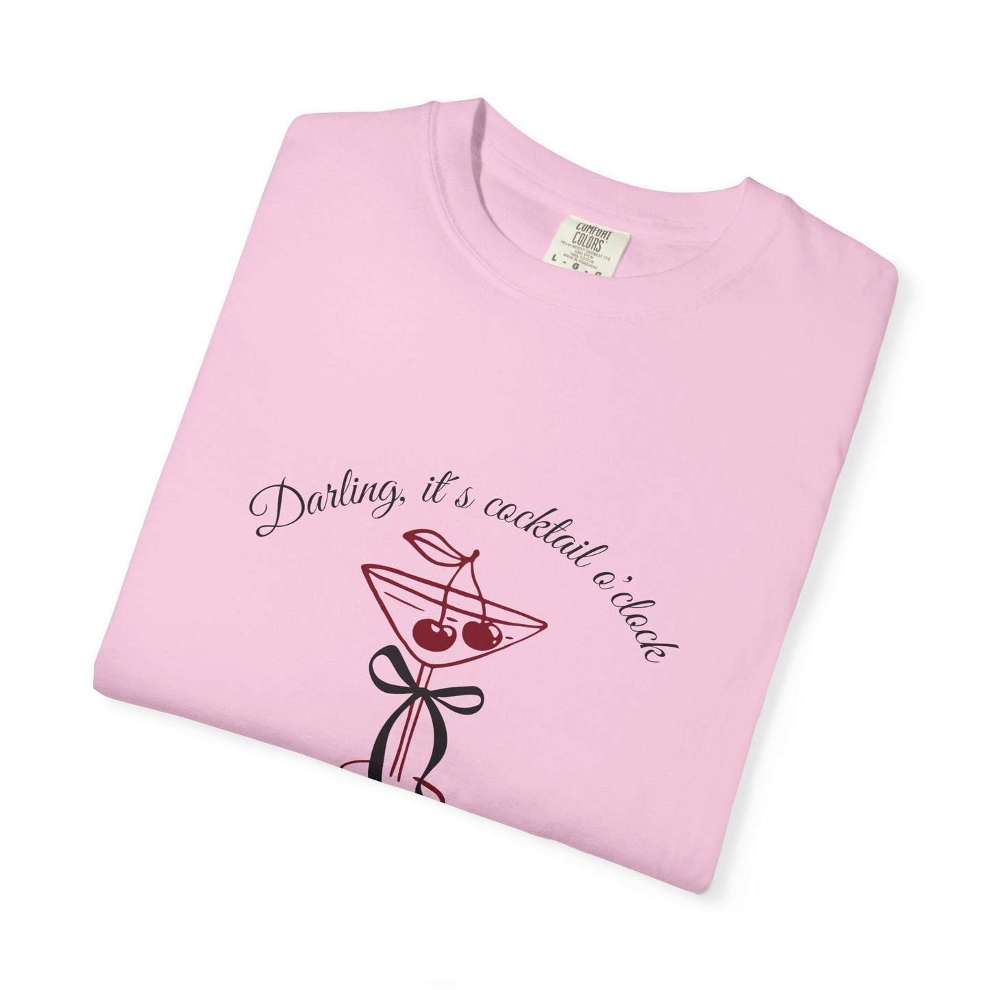 Folded pink t-shirt with cocktail graphic and text on a white background
