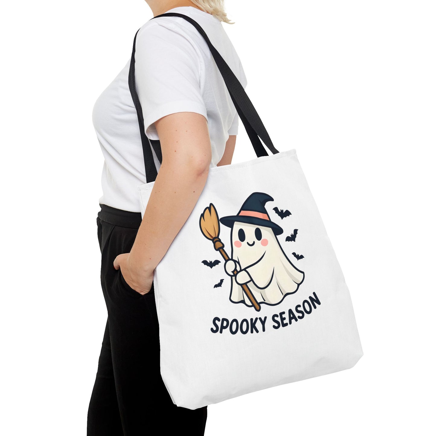 Person wearing tote bag with a ghost holding a broom and 'Spooky Season' text on a white background