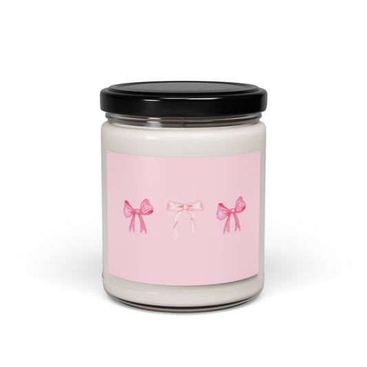 Candle jar with a pink label featuring three bows on a white background
