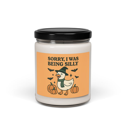 Candle jar with a Halloween-themed label featuring a duck in a witch hat and pumpkins on an orange background.