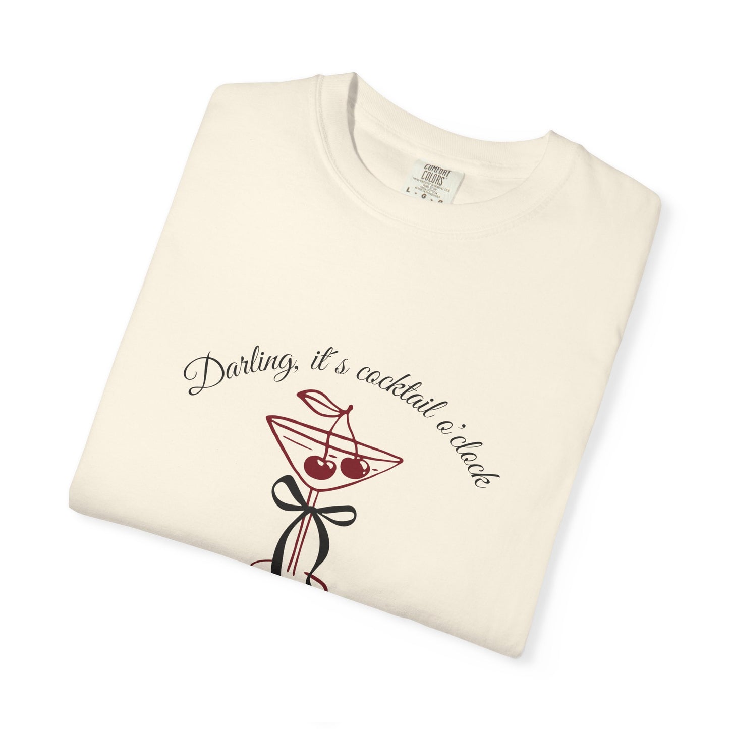 Folded cream-colored t-shirt with cocktail graphic and text on a white background