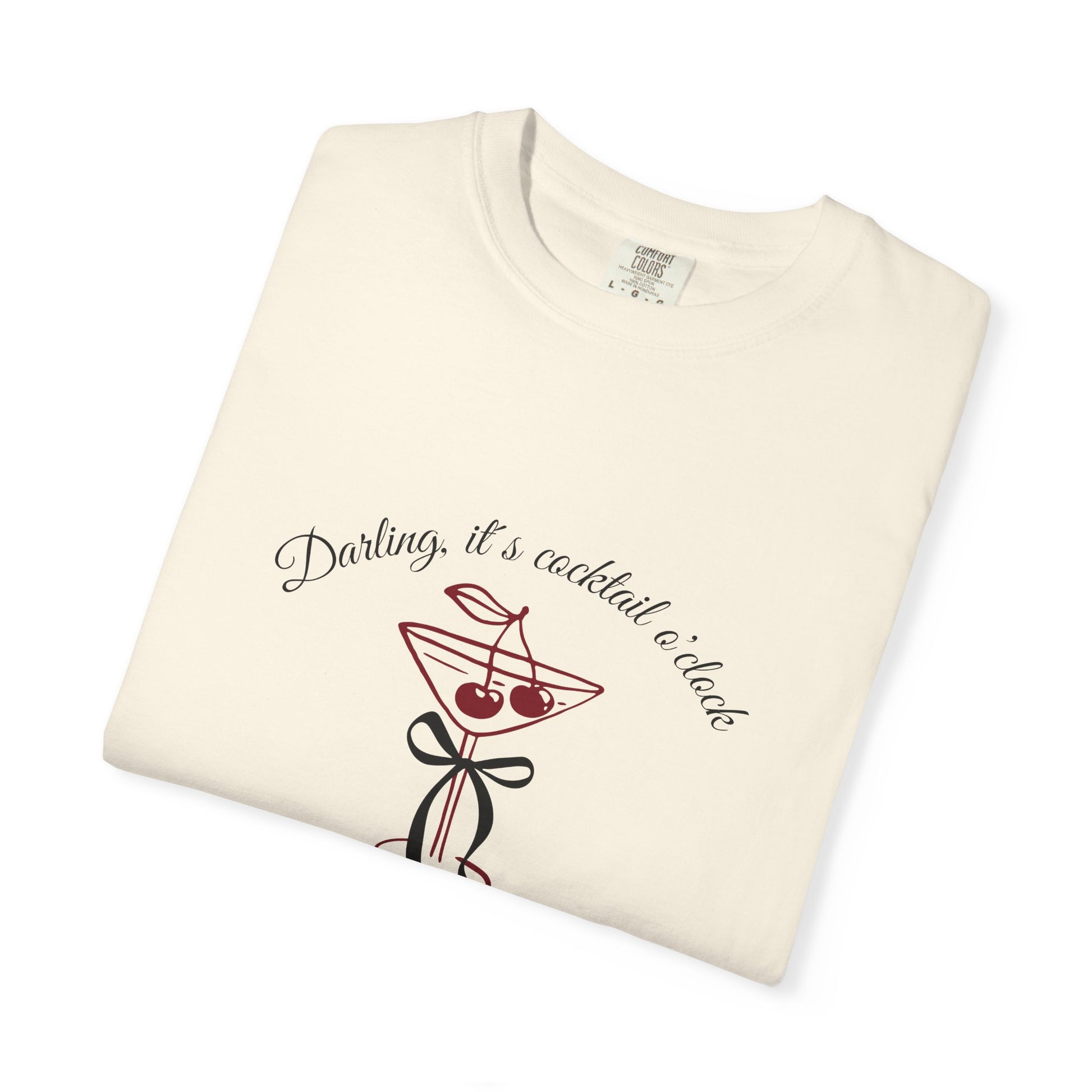 Folded cream-colored t-shirt with cocktail graphic and text on a white background